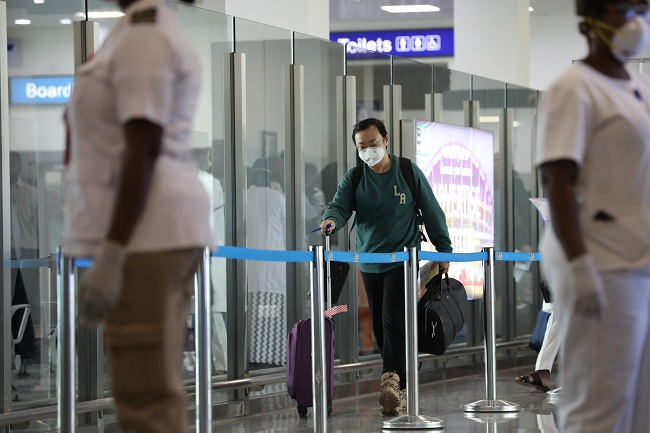 Health workers to scan for the corona virus on standy while a traveler approaches the entrance of Nnamdi Azkiwe International Airport, Abuja. PHOTO: Sodiq Adelakun