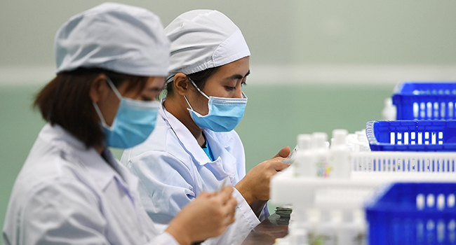 Workers manufacture hand sanitizer at a factory in Hanoi on February 14, 2020 amid concerns of the COVID-19 coronavirus outbreak. Nhac NGUYEN / AFP