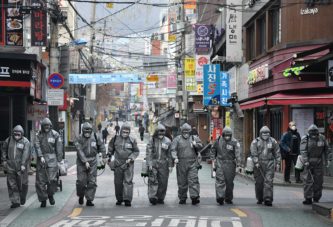 South Korean soldiers wearing protective gear spray disinfectant to help prevent the spread of the COVID-19 coronavirus, at a shopping district in Seoul on March 4, 2020. Photo: Jung Yeon-je / AFP