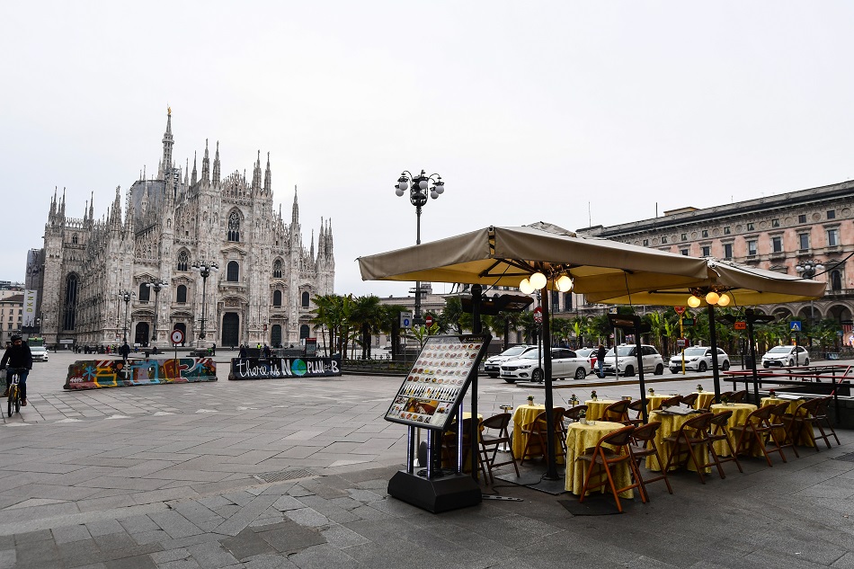 A general view shows a cafe terrace on Piazza del Duomo by the cathedral in downtown Milan on March 10, 2020. Italy imposed unprecedented national restrictions on its 60 million people on March 10, 2020 to control the deadly coronavirus, as China signalled major progress in its own battle against the global epidemic. Miguel MEDINA / AFP