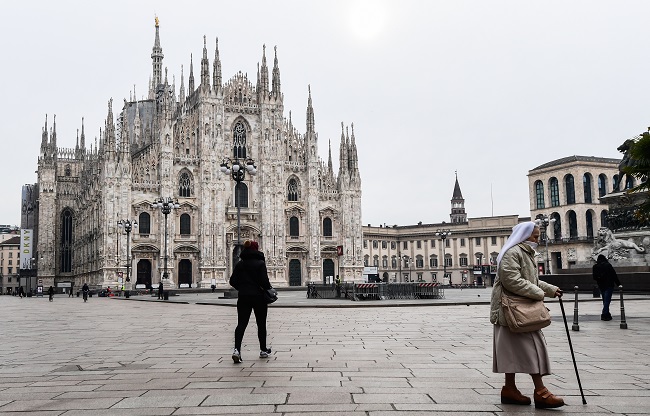 A nun walks across Piazza del Duomo by the cathedral in downtown Milan on March 10, 2020. Italy imposed unprecedented national restrictions on its 60 million people on March 10, 2020 to control the deadly coronavirus, as China signalled major progress in its own battle against the global epidemic. Miguel MEDINA AFP