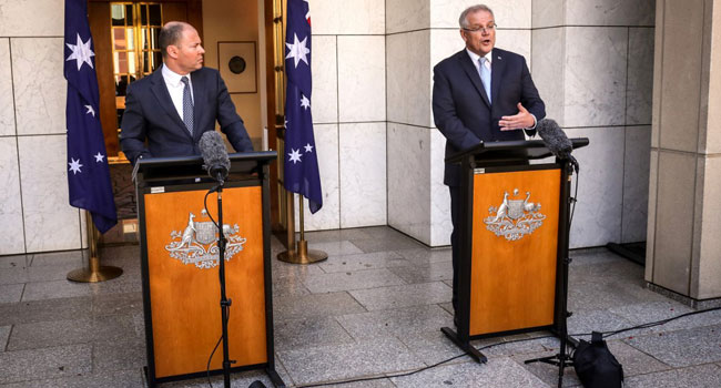 Australian Prime Minister Scott Morrison (R) speaks as he stands with the Australian Treasurer Josh Frydenberg during a press conference at Australia's Parliament House in Canberra on March 22, 2020. DAVID GRAY / AFP