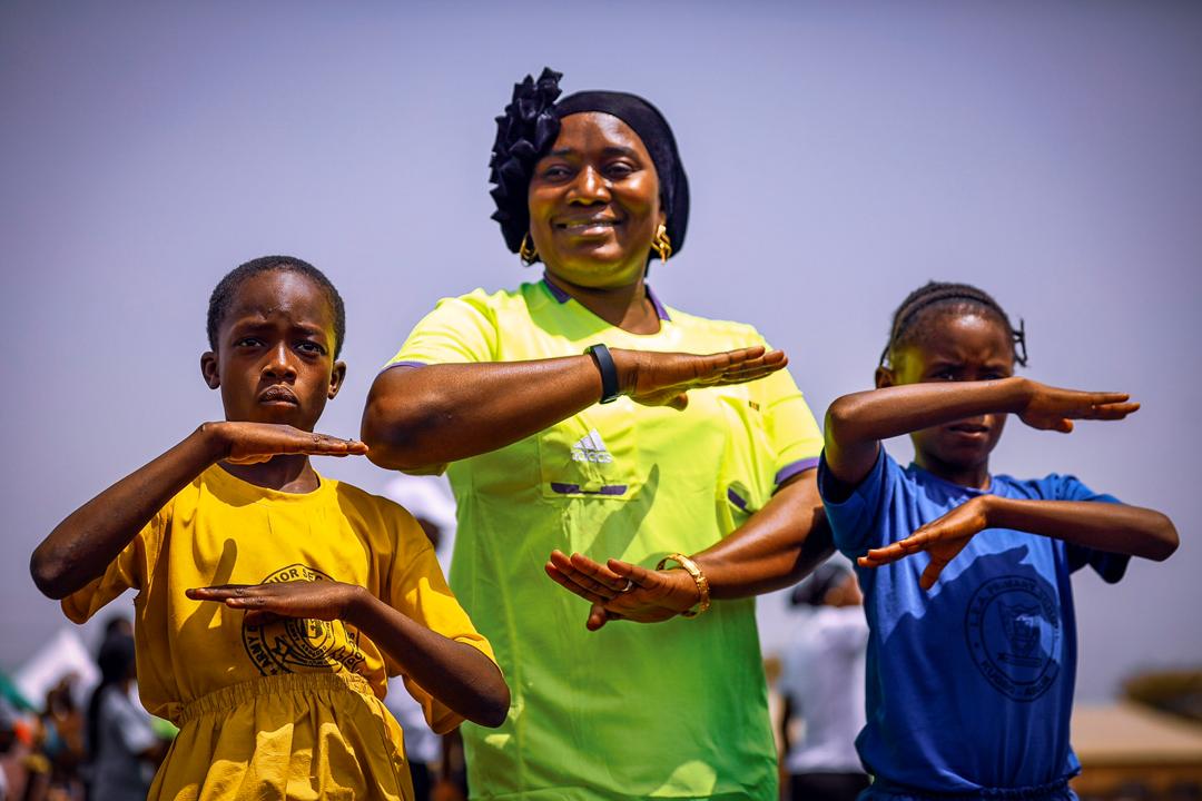 A woman and her two daughters line up with their hands arranged as equality signs on March 5, 2020, during a friendly football match to commemorate the International Women’s Day in Abuja. Photo: Sodiq Adelakun/ Channels TV