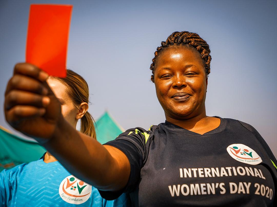 A Woman displays a red card on March 1, 2020, as a sign to checkmate inequality during a friendly football match to commemorate the International Women’s Day in Abuja. Photo: Sodiq Adelakun/ Channels TV