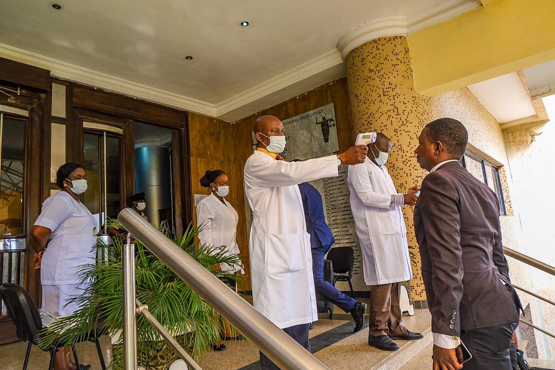 Medical workers of the Federal High Court in Abuja check the temperature of people before allowing them into the court on Monday, March 23, 2020. Channels Television / Sodiq Adelakun.