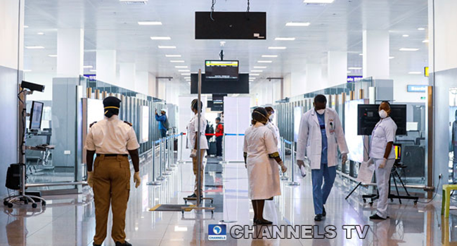 A security official and medical personnel move around at the Nnamdi Azikwe International Airport in Abuja. Photo: Sodiq Adelakun / Channels TV