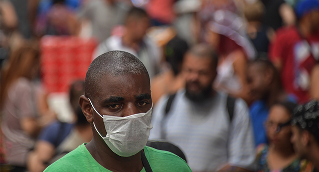 A man wearing a face mask as a preventive measure against the spread of the new coronavirus, COVID-19, walks in downtown Sao Paulo, Brazil on March 16, 2020. NELSON ALMEIDA / AFP