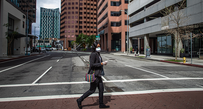 A woman walks wearing a mask to protect herself from the Coronavirus (Covid-19) in Los Angeles, California on March 19, 2020. Apu GOMES / AFP