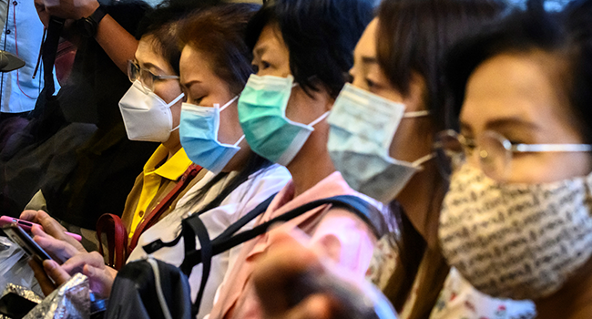 Commuters wearing facemasks amid fears of the spread of the COVID-19 novel coronavirus ride a train in Bangkok on March 9, 2020. Mladen ANTONOV / AFP
