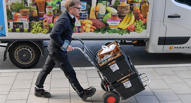 A worker delivers grocery bags to households in Stockholm, Sweden, on March 21, 2020 as internet shopping of food stuffs have skyrocketed in Sweden since the start of the Coronavirus Covid-19 outbreak. Anders WIKLUND / TT NEWS AGENCY / AFP