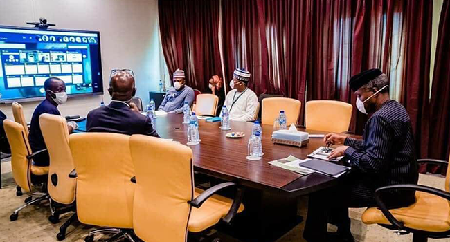 Vice President Yemi Osinbajo (right) wears a mask during a meeting. Photo: Tolani Alli