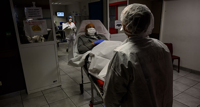 French firefighters from Marins-Pompiers of Marseille wearing protective equipments escort on a stretcher an 84 year-old man, suspected of being infected with the novel coronavirus, at the emergency services of Hopital Nord hospital in Marseille, on April 6, 2020, on the twenty-first day of a lockdown in France aimed at curbing the spread of the COVID-19. Christophe SIMON / AFP