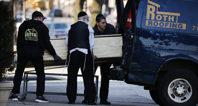 A casket is placed into a van outside of a funeral home in the heavily Orthodox Borough Park neighborhood of Brooklyn which has scene a large number of deaths due to the coronavirus on April 19, 2020 in New York City. Spencer Platt/Getty Images/AFP