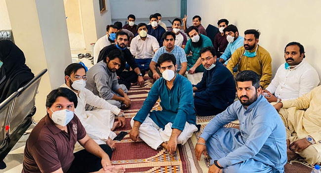 In this handout photograph released by the Young Doctors Association (YDA) Punjab and taken on April 24, 2020, doctors wearing facemasks sit in during a hunger strike protest at the Punjab Health Secretary in Lahore. Handout / YOUNG DOCTORS ASSOCIATION (YDA) of Pakistan / AFP
