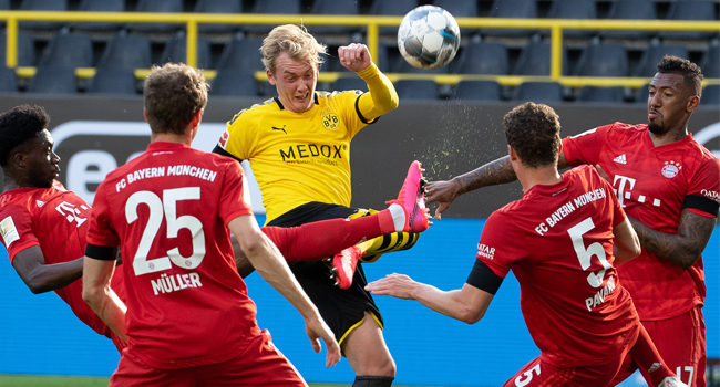 Dortmund's German forward Julian Brandt (C) vies for the ball with (L-R) Bayern Munich's Canadian midfielder Alphonso Davies, Bayern Munich's German forward Thomas Mueller, Bayern Munich's French defender Benjamin Pavard and Bayern Munich's German defender Jerome Boateng during the German first division Bundesliga football match BVB Borussia Dortmund v FC Bayern Munich on May 26, 2020 in Dortmund, western Germany. Federico GAMBARINI / POOL / AFP