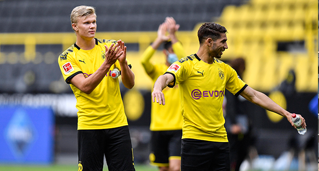 Dortmund's Norwegian forward Erling Braut Haaland (L) claps hands to the empty tribune after winning the German first division Bundesliga football match BVB Borussia Dortmund v Schalke 04 on May 16, 2020 in Dortmund, western Germany. Martin Meissner / POOL / AFP