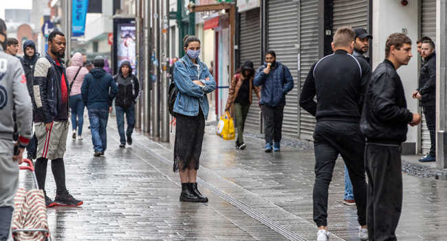 People employ social distancing as they queue at shops in Dublin City centre in Ireland on May 18, 2020. PAUL FAITH / AFP