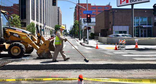 Roadworks continue, now with a facemask, as some essential jobs have kept segments of the population employed as the stay-at-home orders continue in Los Angeles, California on May 4, 2020. Frederic J. BROWN / AFP