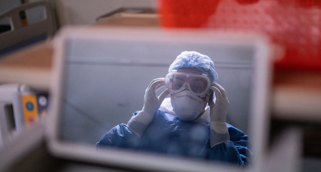 A health worker is reflected on a mirror while preparing to the COVID-19 zone of a hospital in Atizapan, Mexico, on May 22, 2020, amid the new coronavirus pandemic. PEDRO PARDO / AFP