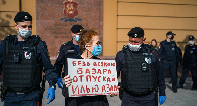 Police officers detain Russian photographer Victoria Ivleva (C) during a solo picket in support of journalist and activist Ilya Azar outside the Moscow police headquarters in Moscow on May 28, 2020. Dimitar DILKOFF / AFP