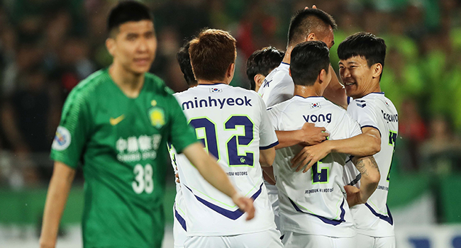 In this file photo taken on May 7, 2019, Jeonbuk Hyundai Motors players celebrate scoring a goal during the AFC Champions League group stage football match between China's Beijing Guoan and South Korea's Jeonbuk Hyundai Motors in Beijing. STR / AFP