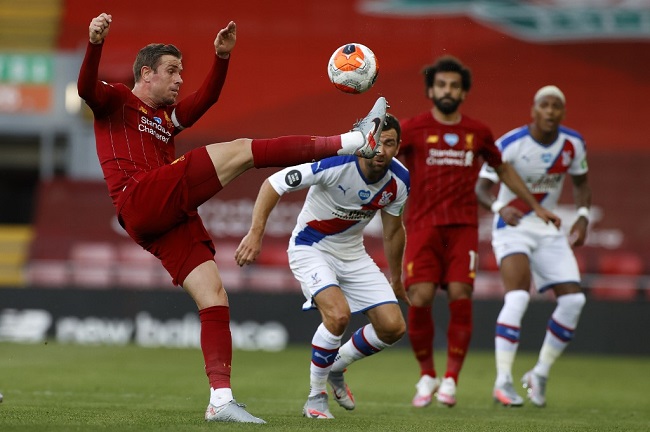 Liverpool's English midfielder Jordan Henderson (L) clears the ball during the English Premier League football match between Liverpool and Crystal Palace at Anfield in Liverpool, north west England on June 24, 2020. (Photo by PHIL NOBLE / POOL / AFP) / RESTRICTED TO EDITORIAL USE. No use with unauthorized audio, video, data, fixture lists, club/league logos or 'live' services. Online in-match use limited to 120 images. An additional 40 images may be used in extra time. No video emulation. Social media in-match use limited to 120 images. An additional 40 images may be used in extra time. No use in betting publications, games or single club/league/player publications. /