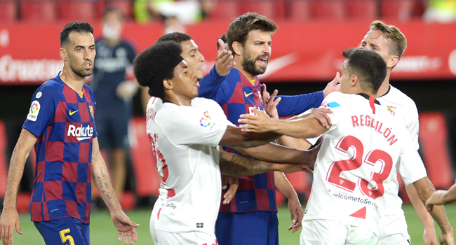 Barcelona's Spanish defender Gerard Pique (C) argues with Sevilla's Spanish defender Sergio Reguilon (R) during the Spanish league football match between Sevilla FC and FC Barcelona at the Ramon Sanchez Pizjuan stadium in Seville on June 19, 2020. CRISTINA QUICLER / AFP