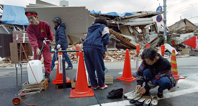 Earthquake refugees gather at a water source on a street of Kobe's Nada area on February 16, 1995 following the Great Hanshin Earthquake nearly one month ago. Kazuhiro NOGI / AFP