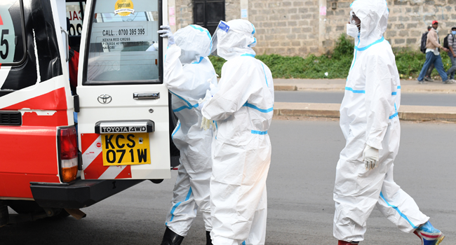 Kenya Redcross paramedics wearing personal protective equipment (PPE) prepare to assist a COVID-19 coronavirus patient that is inside the ambulance before taking him to the hospital, in Nairobi June on 3, 2020. Simon MAINA / AFP