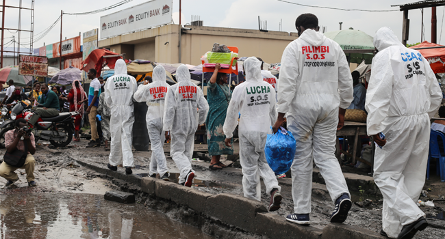 Activists walk along the street during a COVID-19 coronavirus awareness campaign in Kinshasa on May 29, 2020. SAMIR TOUNSI / AFP