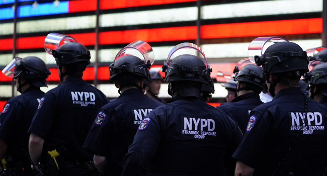 In this file photo taken on June 01, 2020 NYPD police officers watch demonstrators in Times Square during a "Black Lives Matter" protest. TIMOTHY A. CLARY / AFP