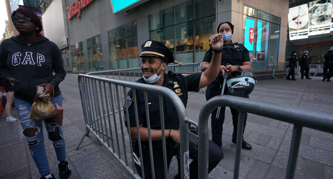 A New York City police officer takes a knee during a demonstration by protesters in Times Square over the death of George Floyd by a Minneapolis police officer at a rally on May 31, 2020 in New York. Bryan R. Smith / AFP