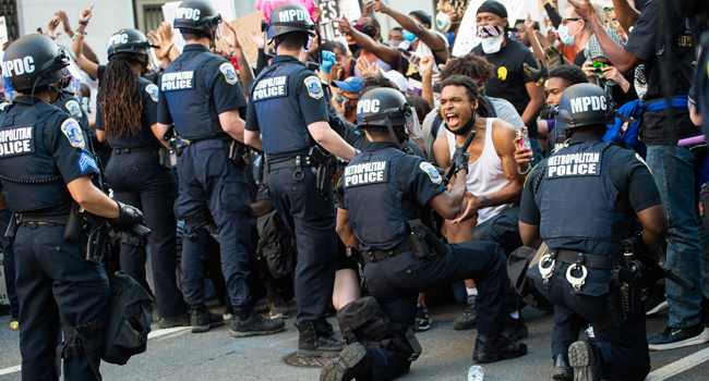 A man screams with emotion as he sees a policeman take a knee while hundreds protest the death of George Floyd next to the White House on May 31, 2020 in Washington, DC. ROBERTO SCHMIDT / AFP