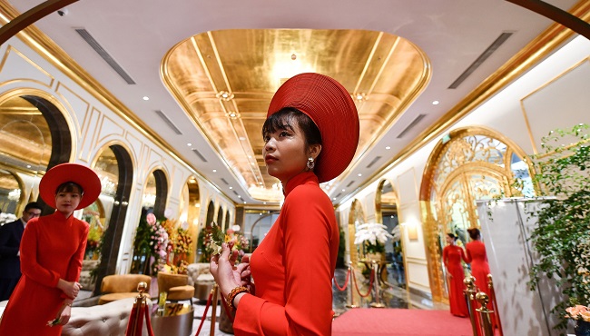 Staff wait to welcome guests in the lobby of the newly-inaugurated Dolce Hanoi Golden Lake hotel, the world's first gold-plated hotel, in Hanoi on July 2, 2020. (Photo by Manan VATSYAYANA / AFP)