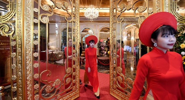 Staff wait to welcome guests in the lobby of the newly-inaugurated Dolce Hanoi Golden Lake hotel, the world's first gold-plated hotel, in Hanoi on July 2, 2020. (Photo by Manan VATSYAYANA / AFP)