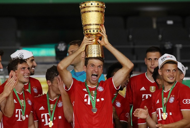 Bayern Munich's German forward Thomas Mueller raises the German Cup (DFB Pokal) trophy as he and his teammates celebrate winning the final football match Bayer 04 Leverkusen v FC Bayern Munich at the Olympic Stadium in Berlin on July 4, 2020. (Photo by Alexander Hassenstein / POOL / AFP) 