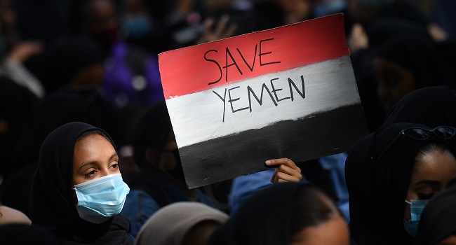 A protester holds a Yemeni flag-themed placard in Parliament Square in London on July 5, 2020, as she demonstrates against the continued conflict in Yemen. - Yemen has been locked in conflict since the Huthis took control of Sanaa in 2014 and went on to seize much of the north. The crisis escalated when the Saudi-led coalition intervened the following year to support Yemen's internationally-recognised government. Tens of thousands of people, mostly civilians, have been killed and millions displaced in what the United Nations has called the world's worst humanitarian disaster. (Photo by JUSTIN TALLIS / AFP)