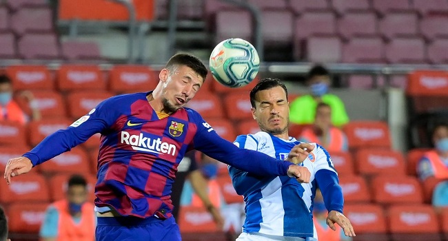 Barcelona's French defender Clement Lenglet (L) vies with Espanyol's Spanish forward Javier Puado during the Spanish League football match between Barcelona and Espanyol at the Camp Nou stadium in Barcelona on July 8, 2020. (Photo by LLUIS GENE / AFP)