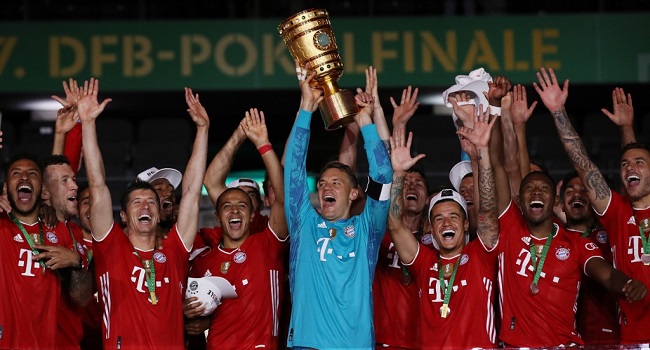 Bayern Munich's German goalkeeper Manuel Neuer raises the German Cup (DFB Pokal) trophy as he and his teammates celebrate winning the final football match Bayer 04 Leverkusen v FC Bayern Munich at the Olympic Stadium in Berlin on July 4, 2020. (Photo by Alexander Hassenstein / POOL / AFP)