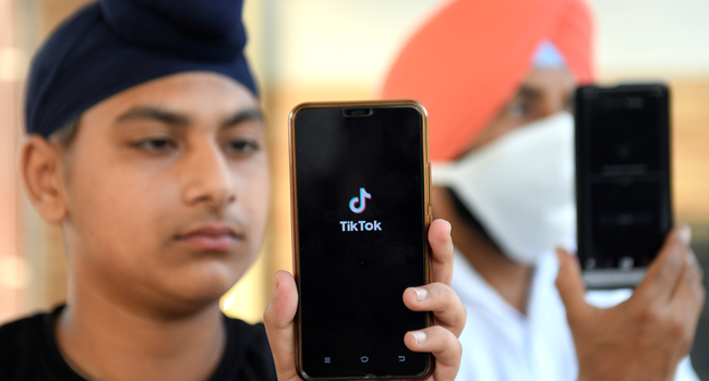 In this file photo taken on June 30, 2020, Indian mobile users browse through the Chinese owned video-sharing 'Tik Tok' app on smartphones in Amritsar. NARINDER NANU / AFP