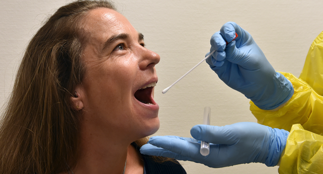 In this file photo taken on July 10, 2020, patient Heike Abicht poses for a photo of a testing situation in a corona screening station in the medical center of the Franz-Josef-Strauss airport in Munich, southern Germany, amid the novel coronavirus COVID-19 pandemic. Christof STACHE / AFP