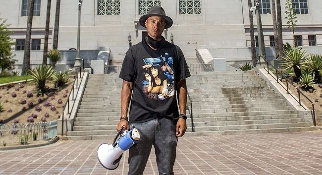 Tyson Suzuki, 27, film editor and founder of "Active Advocate" poses in front of City hall, June 23, 2020, in Los Angeles, California. (Photo by VALERIE MACON / AFP)
