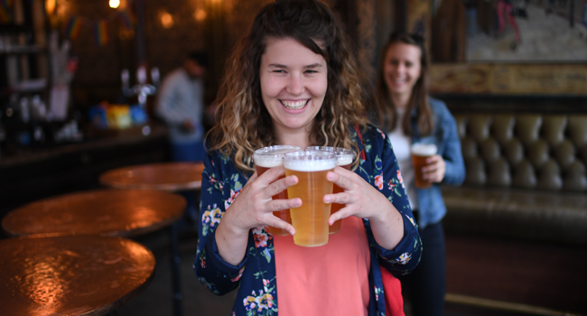 Customers leave with pints of beer for takeaway at The Ten Bells pub in east London on June 27, 2020. DANIEL LEAL-OLIVAS / AFP