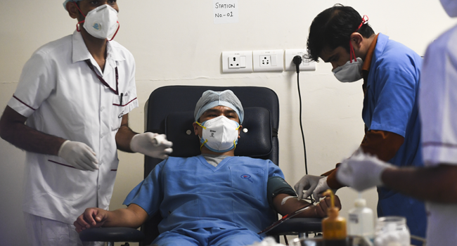 A plasma donor (C) is seen at the newly inaugurated plasma bank of the Institute of Liver and Biliary Sciences (ILBS) donating plasma for the treatment of patients suffering from the COVID-19 coronavirus, in New Delhi on July 2, 2020. Sajjad HUSSAIN / AFP