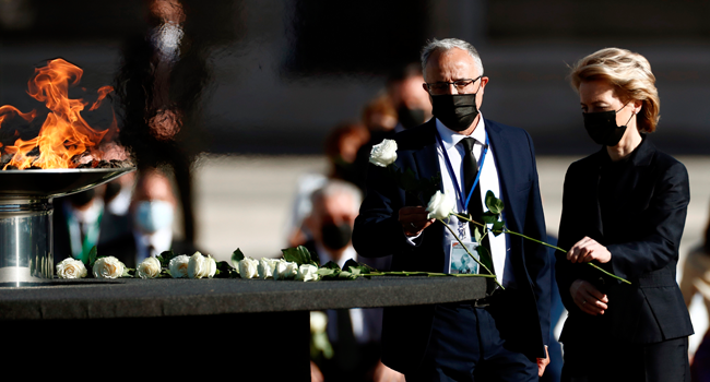 President of the European Commision Ursula von der Leyen (R) leaves a whote rose next to a cauldron as she attends a state ceremony to honour the 28,400 victims of the coronavirus crisis as well as those public servants who have been fighting on the front line against the pandemic in Spain, on July 16, 2020, at the Royal Palace in Madrid. Mariscal / POOL / AFP