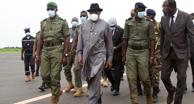 Former Nigerian President Goodluck Jonathan (2L) walks at the International Airport in Bamako upon his arrival on August 22, 2020 next to by Malick Diaw (L), the Vice President of the CNSP (National Committee for the Salvation of the People). ANNIE RISEMBERG / AFP