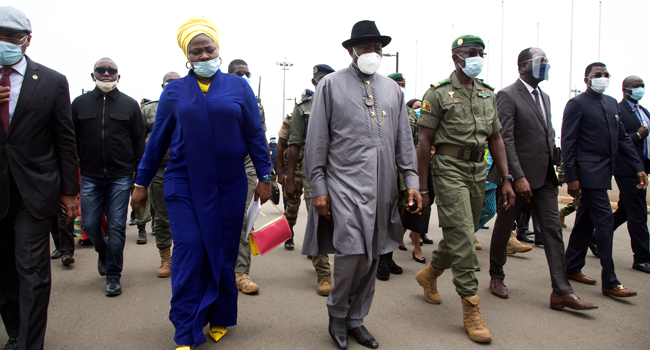 Former Nigerian President Goodluck Jonathan (C) walks at the International Airport in Bamako upon his arrival on August 22, 2020 next to by Malick Diaw (4R), the Vice President of the CNSP (National Committee for the Salvation of the People) ANNIE RISEMBERG / AFP