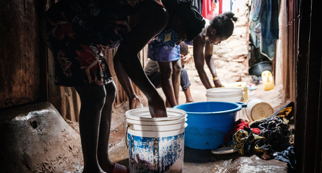 Linet (L), 16, who is in about 3 months pregnant helps to wash cloths after an interview for AFP with her sister Carol, 22, about Linet's unexpected pregnancy as schools are closed due to the COVID-19 outbreak, at her sister's home in Raila slum, next to Kibera slum, in Nairobi, on July 15, 2020.  Yasuyoshi CHIBA / AFP