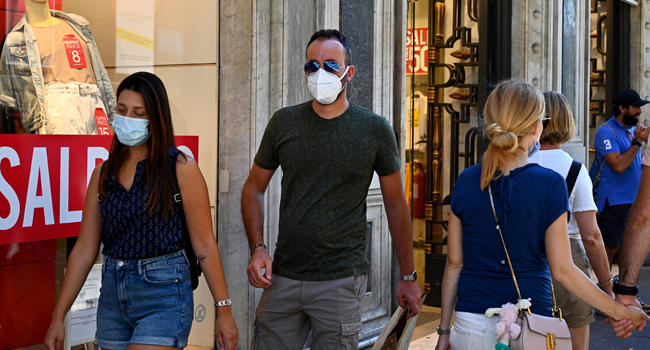 People wearing a face mask walk along the Via del Corso main shopping street on August 20, 2020 in Rome during the COVID-19 infection, caused by the novel coronavirus. Vincenzo PINTO / AFP