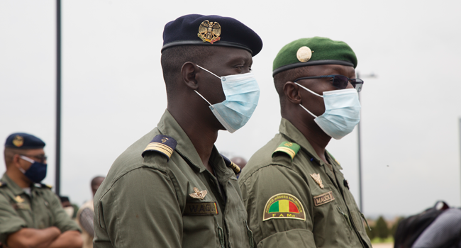 The spokesperson for the CNSP (National Committee for the Salvation of the People) Ismael Wague (L) and Vice president of the CNSP Malick Diaw, wearing face masks, wait to greet former Nigerian president as he arrives at Bamako airport before a meeting between Malian military leaders and an ECOWAS delegation he is heading on August 22, 2020, in an aim to restore order after the military coup, in Bamako. ANNIE RISEMBERG / AFP